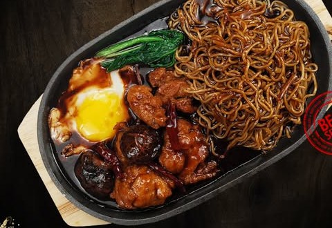 Sizzling yee mee on a hot plate with egg and chicken